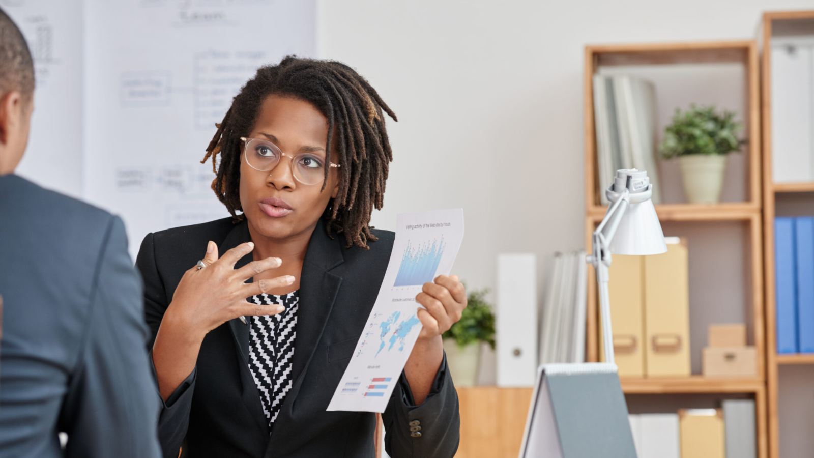 African-American business woman explaining results of her work to colleague